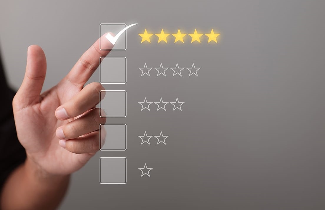 Une main touche et donne une note des cinq étoiles pour indiquer sa satisfaction client concernant un produit